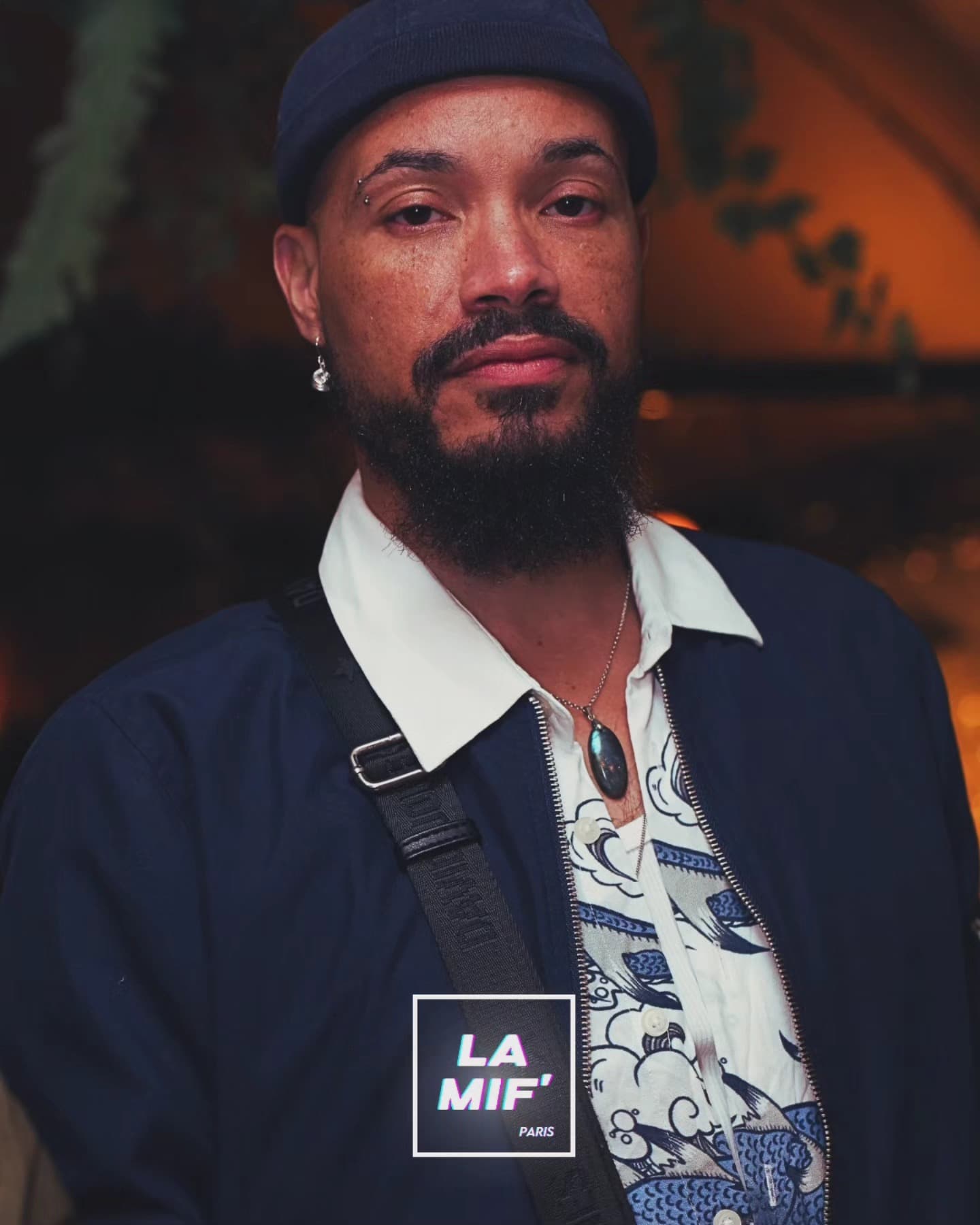 Portrait d'un invité barbu, bonnet et chemise imprimée, lumière tamisée