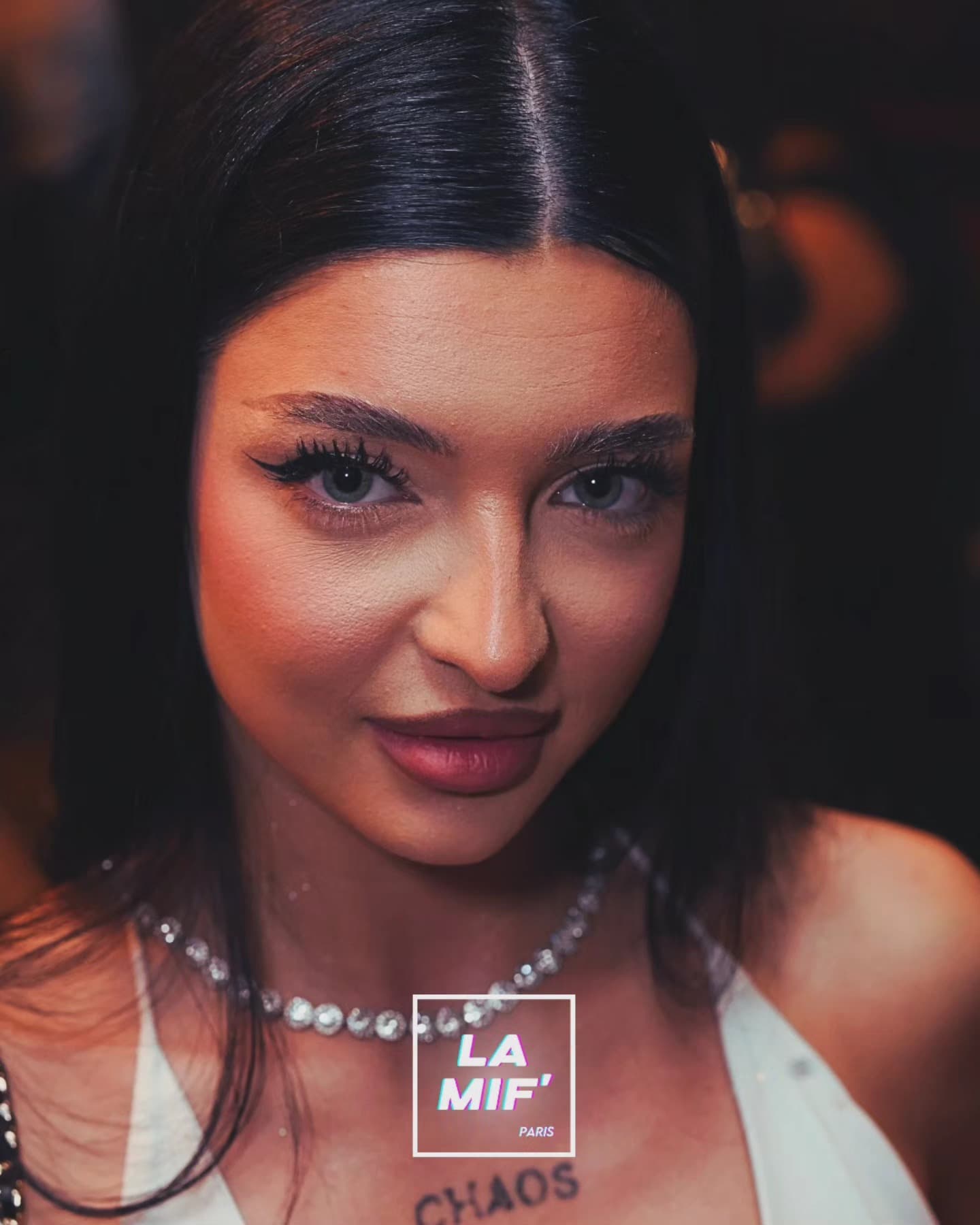 Portrait rapproché d'une invitée sur le dancefloor, lumières chaudes